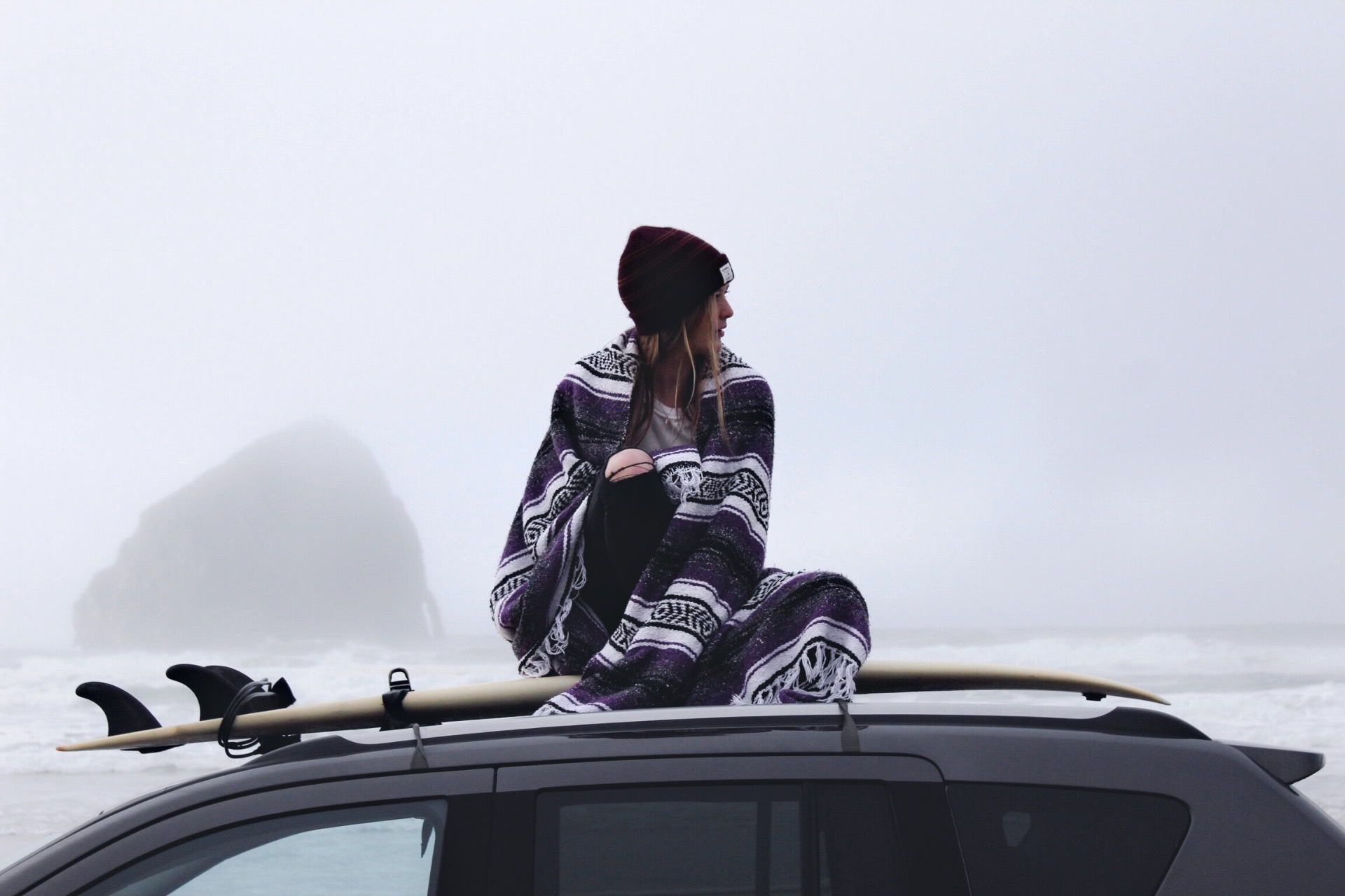 Ro on a car roof with a surfboard